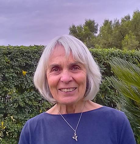 Photo of Suzan Burrell standing in front of a hedge
